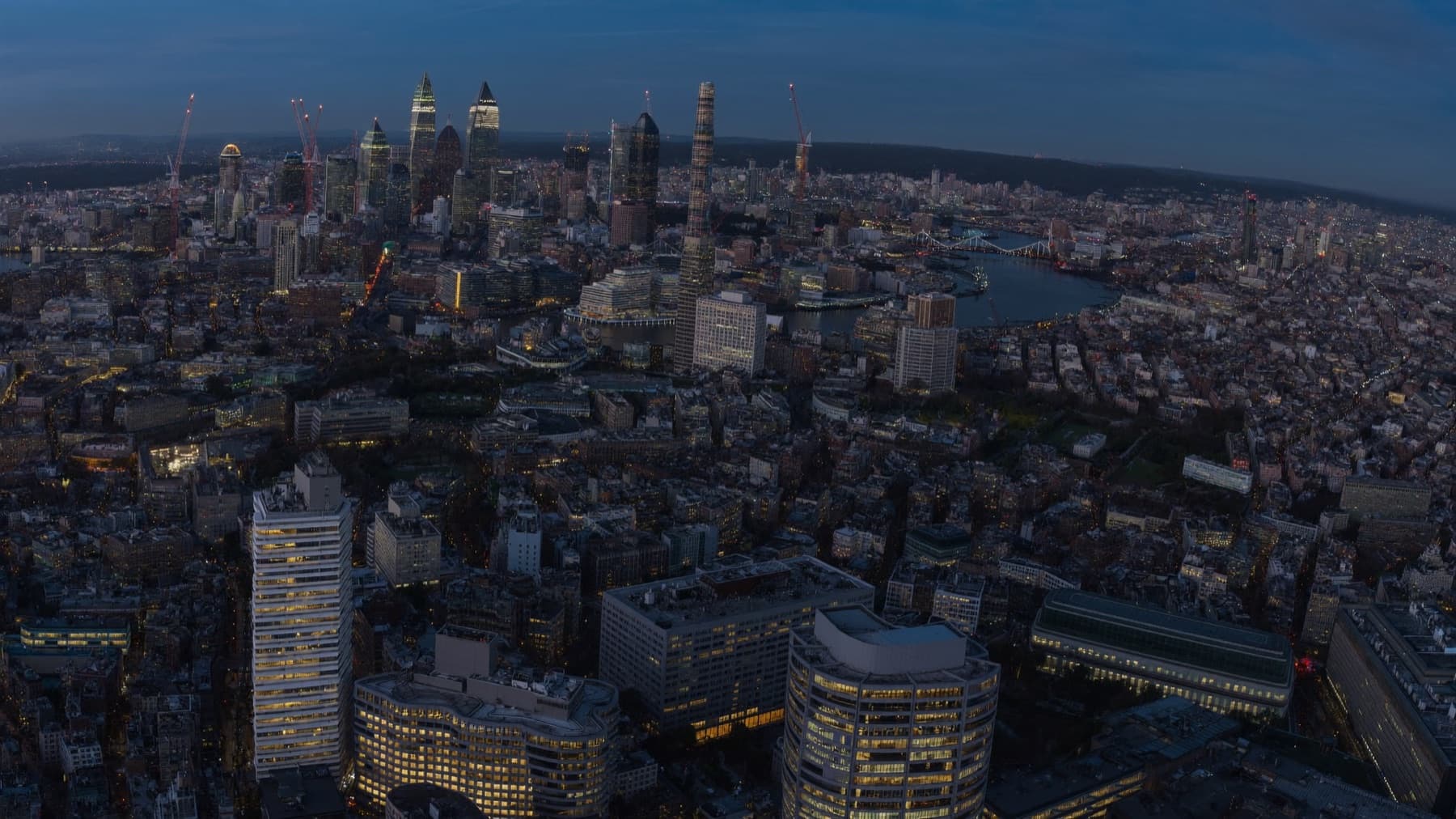 The London skyline at blue hour, windows glowing